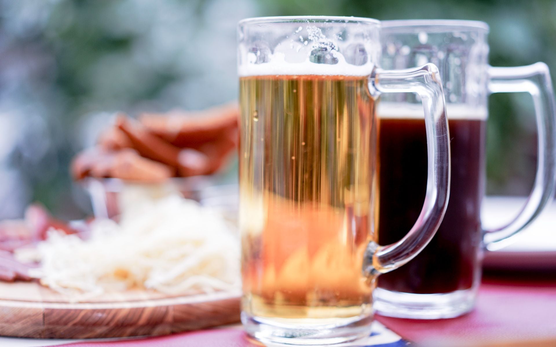 Pints of craft beer on an outdoor picnic table with the Green Mountains in the background on a Vermont summer afternoon